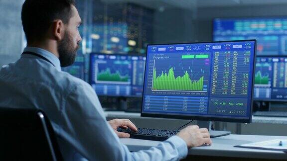 股票市场交易员在显示股票行情数字和图表的计算机上工作