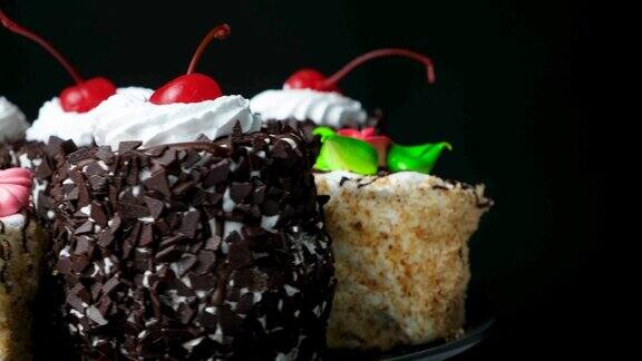 巧克力、樱桃和奶油蛋糕在黑色的背景上旋转