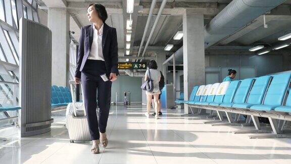 亚洲女商人在机场拉手提箱商务旅行