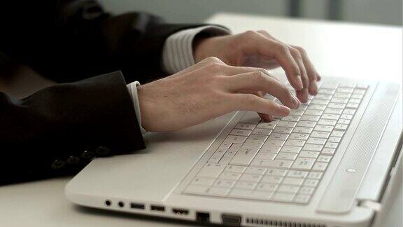 男人的手在键盘笔记本上打字