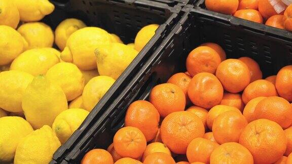 4k展示超市里各种水果出售食品零售货架上的新鲜橙子、橘子和柠檬奇异的水果成熟健康的水果超市购买膳食食品