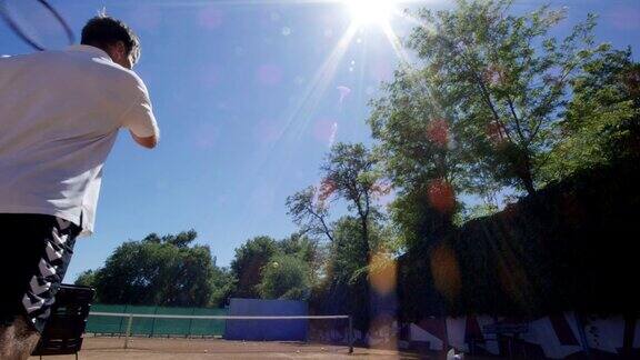 男子在阳光下练习网球发球