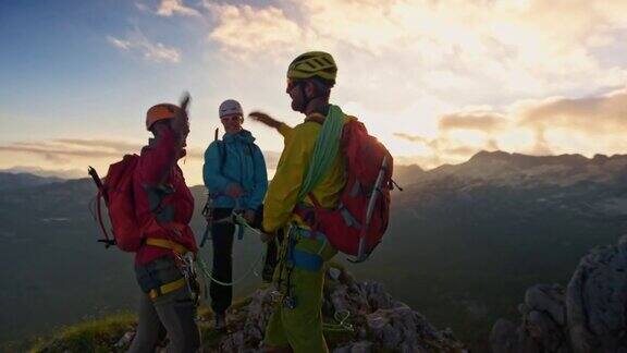 三人登山队在日落时到达山顶