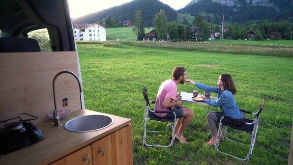 一男一女在露营车旁吃薄饼