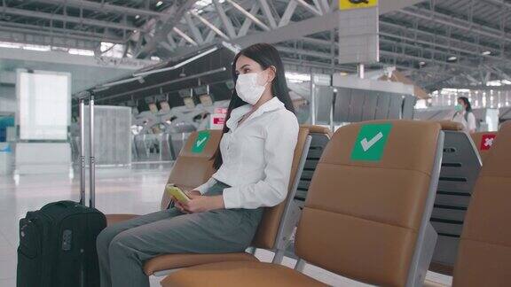 一名商务女性在国际机场戴着防护口罩在新冠肺炎疫情下旅行安全旅行社交距离礼仪新常态旅行理念