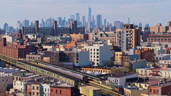 图为在美国纽约布鲁克林布什威克住宅区的高架地铁上两列火车正朝着对方驶去远处可以看到曼哈顿下城无人机视频与后摇相机运动