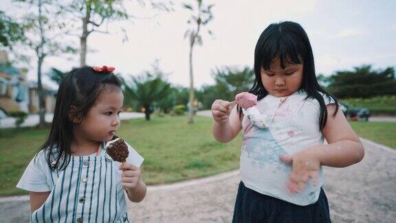 可爱的孩子在户外公园里分享冰淇淋
