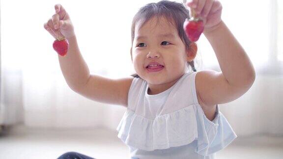 小女孩高兴了喜欢在家吃草莓