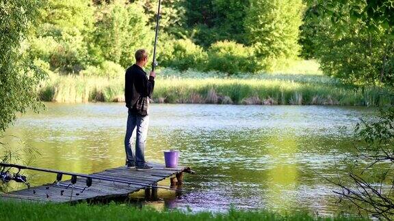一个年轻人在池塘里钓鱼