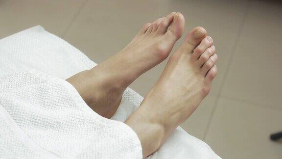 在美容院的白毯子下不动女人的脚病人