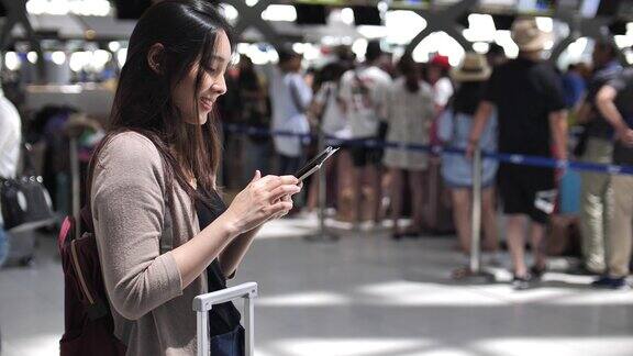 使用手机亚洲女性在机场使用手机