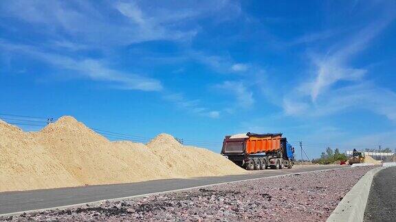 拖拉机用铲斗装载重卡车上的沙子