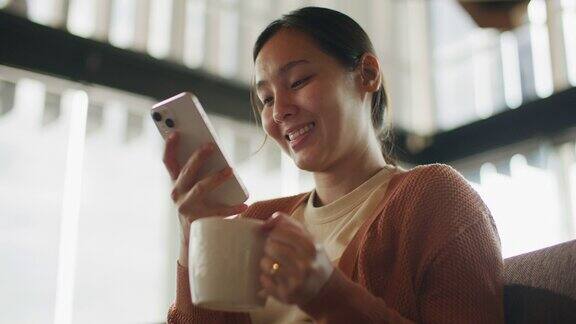 亚洲女性在咖啡店使用智能手机