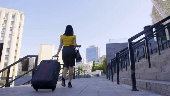 低角度的商务女性与行李行走
