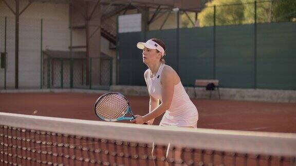 网球运动员伸手去击球女子网球运动员在球场上伸手去打网球