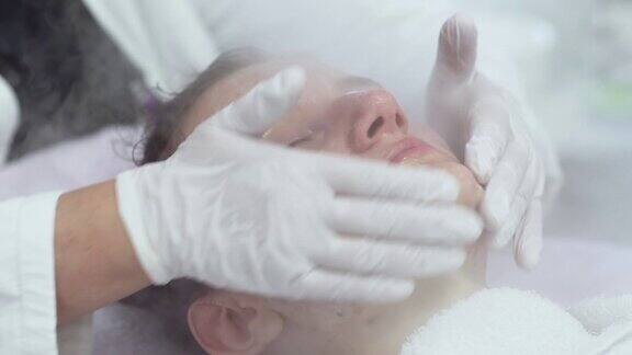 在美容院用化妆蒸笼清洁皮肤的专业面部皮肤护理治疗特写