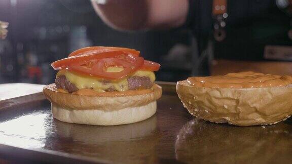 厨师的手准备一个汉堡包与牛肉rissole和奶酪的特写镜头