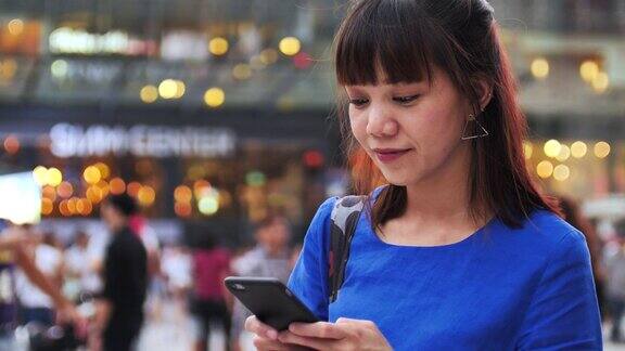 一名日本妇女在城市街道上使用手机