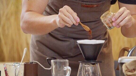 专业的咖啡师手动将水倒在过滤器中的咖啡渣上