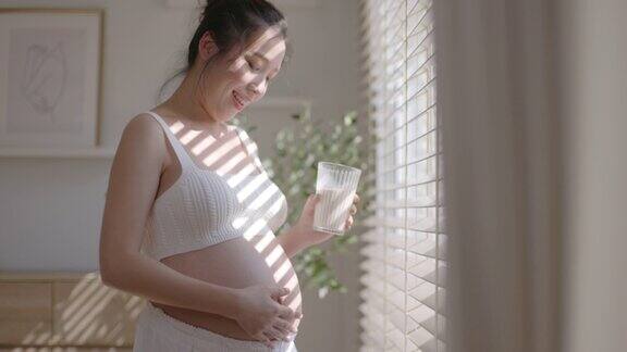 一位亚洲母亲喝鲜奶为未出生的孩子滋养子宫