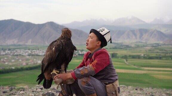 鹰猎人坐在吉尔吉斯斯坦山脉的背景