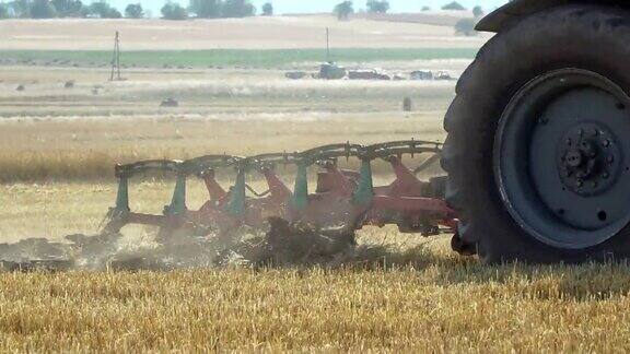 近距离的拖拉机在农业麦田犁地收割机播种小麦