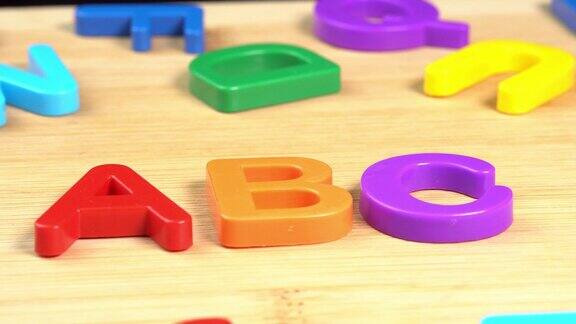 彩色ABC字母在木制背景上旋转学习学校或大学和知识塑料英文字母拉丁文