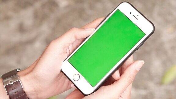 一个女人拿着一个绿色屏幕的智能手机