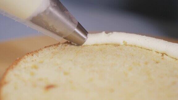 糕点厨师的特写在蛋糕的一边涂上白色奶油