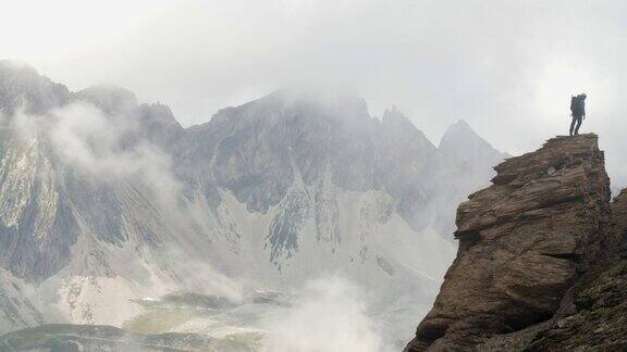 当恶劣天气逼近时一名登山者正在攀登高山脊上的岩石堆