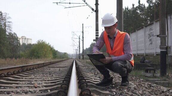 铁路工程师在数枕木的数量并在笔记本上写着铁路维护