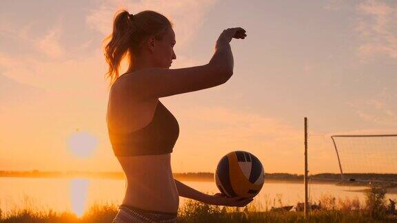 在一个美丽的夏夜运动女孩在空中玩沙滩排球把球击过网白人女性得一分