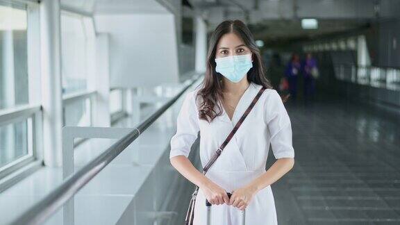 一名女游客在国际机场戴着防护口罩在新冠肺炎疫情下旅行安全旅行社交距离协议新常态旅行理念
