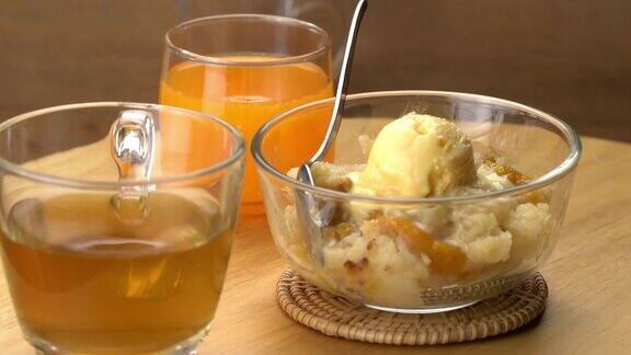 蜜桃馅饼配金属勺香草冰淇淋装在透明玻璃碗里放在竹席上