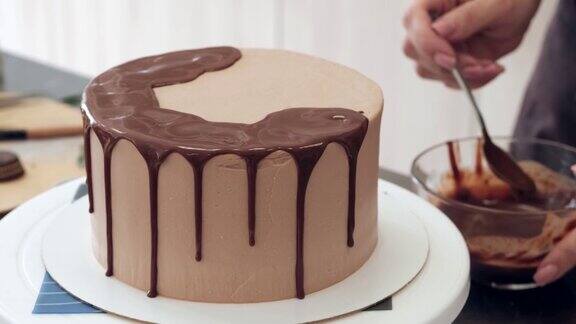 女糕点厨师装饰巧克力蛋糕和滴液体巧克力特写缓慢的运动蛋糕制作过程