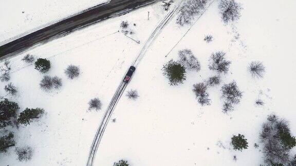 4K航拍:皮卡在白雪覆盖的路上行驶