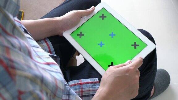一个人在玩绿色屏幕的数字平板电脑