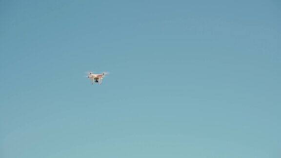 白色遥控无人机配备高分辨率摄像机盘旋在空中蓝天为背景