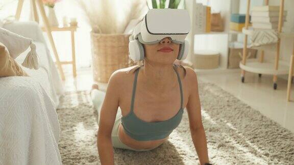 特写年轻的亚洲运动女性戴着虚拟现实耳机运动上衣和打底裤在家里的客厅练习瑜伽饮食和健康减肥