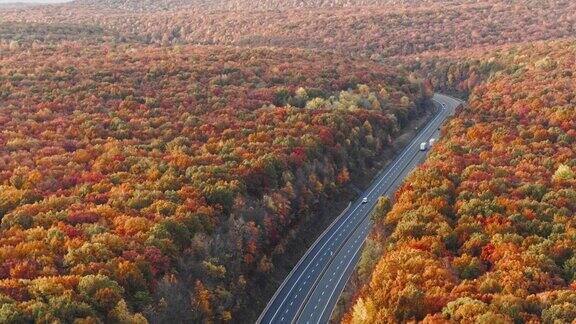 山上的公路在清晨在日落之后在五彩缤纷的秋天季节空中无人机视频与平移摄像机运动