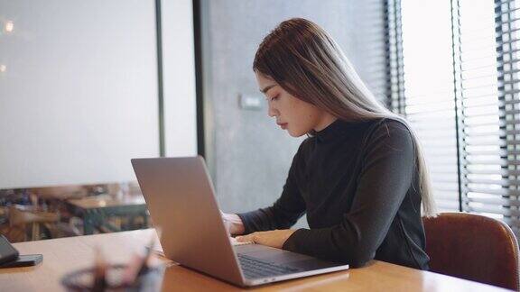 在一间私人学习教室里十几岁的亚洲学生用桌上的笔记本电脑在网上学习