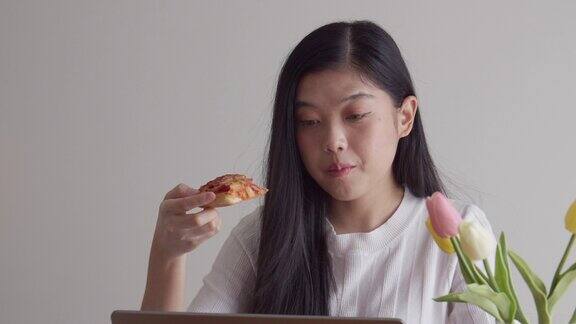 亚洲女人在家吃披萨快餐很可爱
