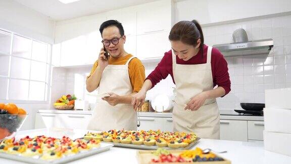 4K亚洲夫妇面包店老板正在接受客户的手机订单