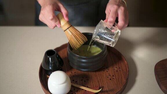 女人用竹打蛋器泡抹茶