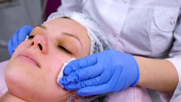 美容师用刷子把女人的面部化学脱皮