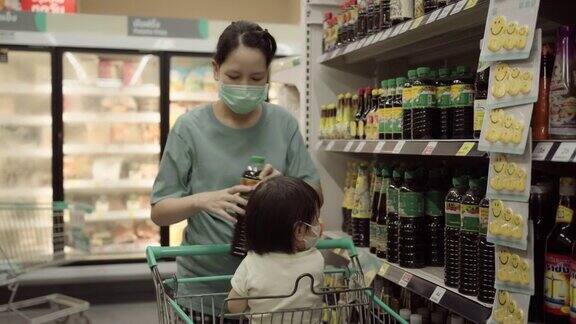 一名亚洲孕妇在超市推着购物车