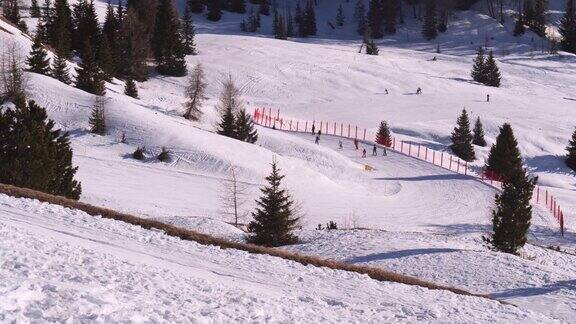 一群高山滑雪者从美丽的雪坡上滑下来雪坡并不太陡