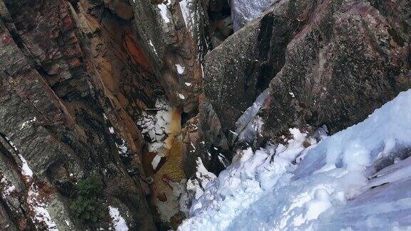 直接头顶无人机拍摄的一个狭窄的山峡谷与雪一条小溪和冰墙(冰公园)在Ouray科罗拉多州