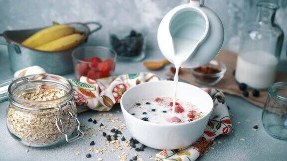 新鲜蓝莓草莓和牛奶牛奶碗:倒牛奶