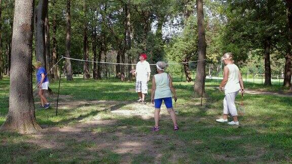 四名高年级学生在公园里打羽毛球